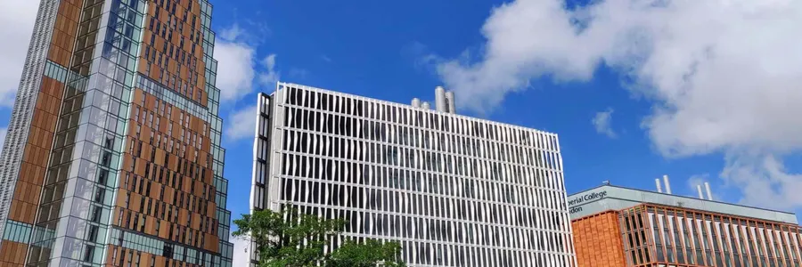 Imperial College's White City campus: tall glass and copper-clad buildings and a white latticed tower block under a blue sky